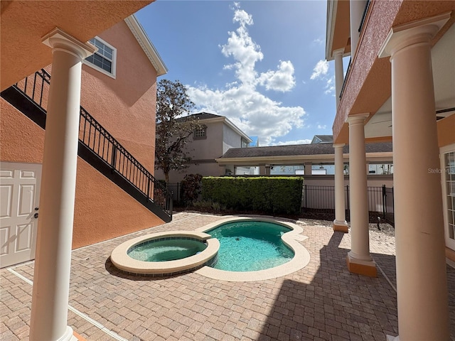 view of pool with a patio area, a pool with connected hot tub, and fence