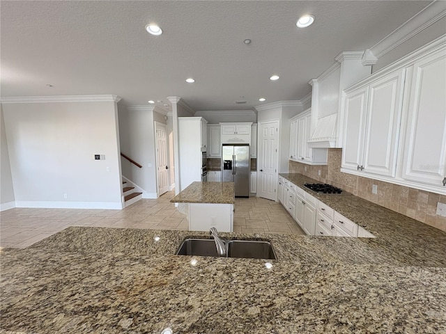 kitchen with a center island, a sink, dark stone counters, stainless steel appliances, and decorative backsplash