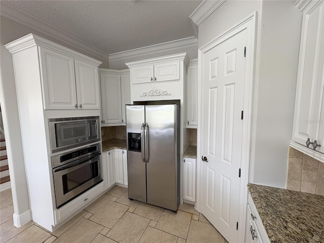 kitchen with dark stone countertops, white cabinets, appliances with stainless steel finishes, a textured ceiling, and backsplash