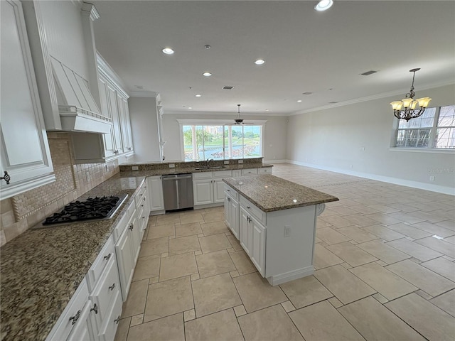 kitchen with ornamental molding, a peninsula, backsplash, stainless steel appliances, and a sink