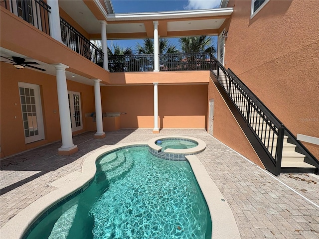 view of pool featuring a patio, a pool with connected hot tub, a ceiling fan, and stairs