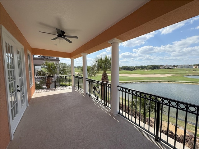 balcony featuring golf course view, french doors, a ceiling fan, and a water view