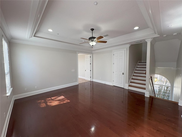 unfurnished living room with baseboards, ornamental molding, a raised ceiling, ceiling fan, and wood finished floors