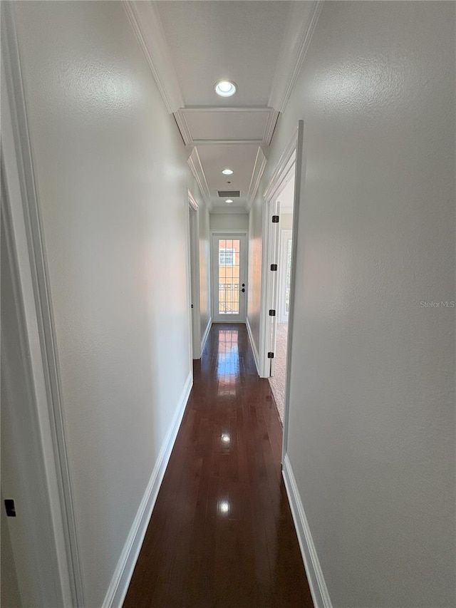 hall with attic access, dark wood-style flooring, baseboards, and ornamental molding