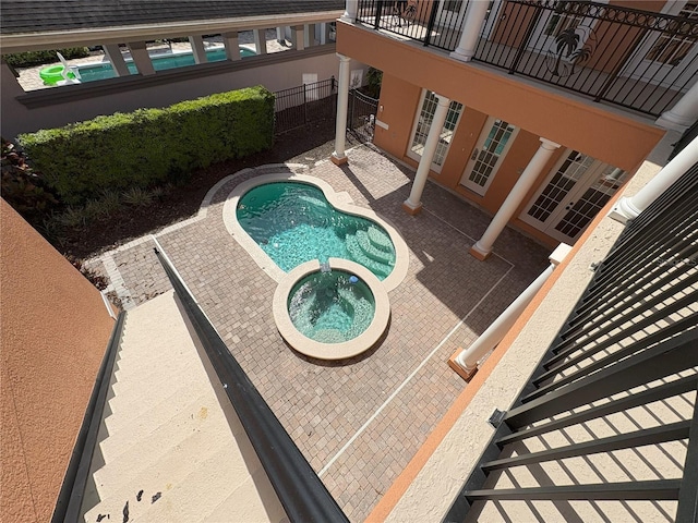 view of swimming pool with a patio, fence, a fenced in pool, and an in ground hot tub