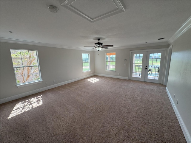 empty room featuring ornamental molding, attic access, and carpet