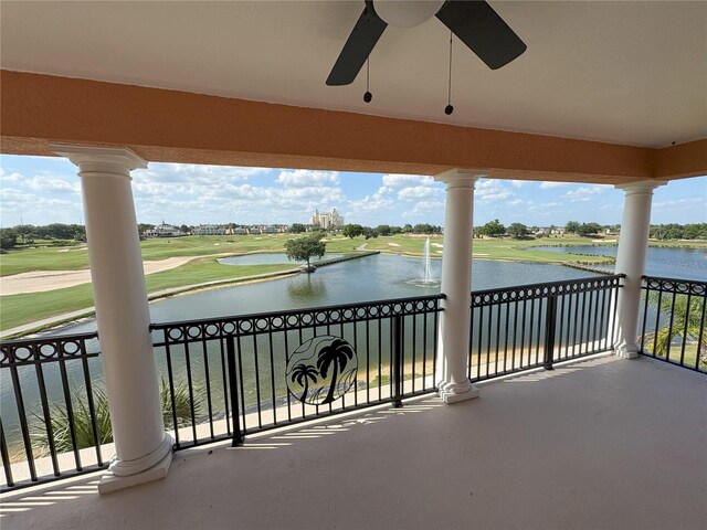 exterior space with a water view, golf course view, a balcony, and a ceiling fan