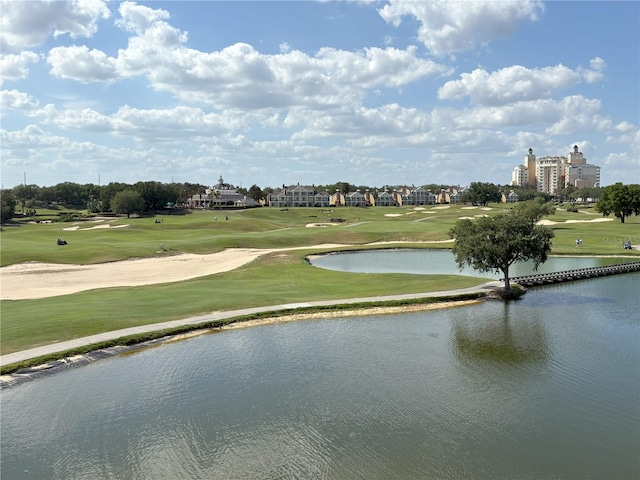 view of community featuring a yard, golf course view, and a water view
