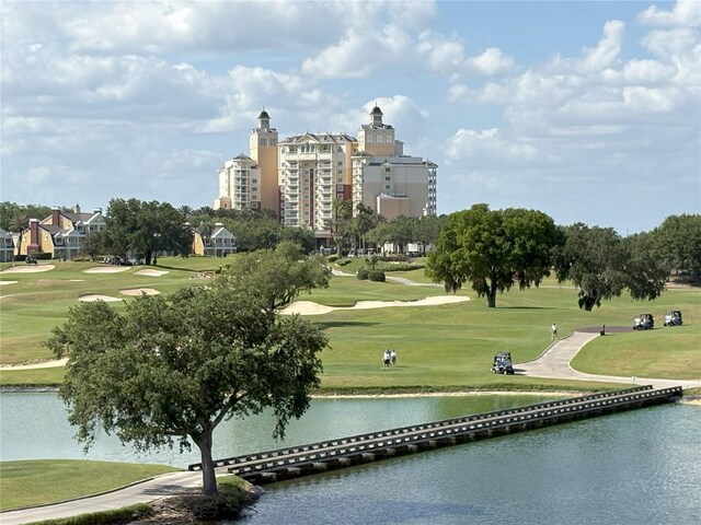 view of property's community with a water view, golf course view, and a lawn