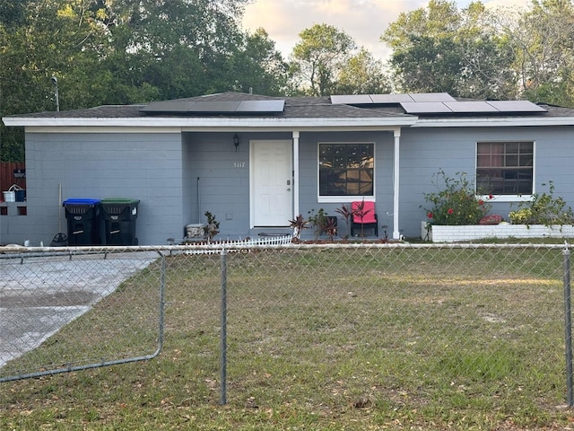 5117 Barnett Pl, Orlando, FL 32808 - ranch-style house with solar panels, a fenced front yard, and a front yard