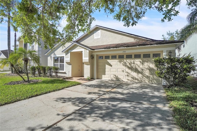 view of front facade with an attached garage, driveway, and stucco siding