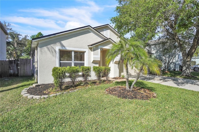 view of front of property featuring a front lawn, fence, and stucco siding