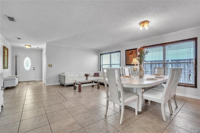 dining room featuring visible vents, ornamental molding, plenty of natural light, and light tile patterned floors