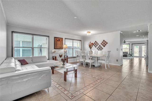 living room featuring crown molding, light tile patterned floors, baseboards, and plenty of natural light