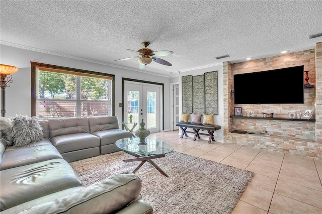 tiled living room featuring french doors, a textured ceiling, a ceiling fan, and visible vents