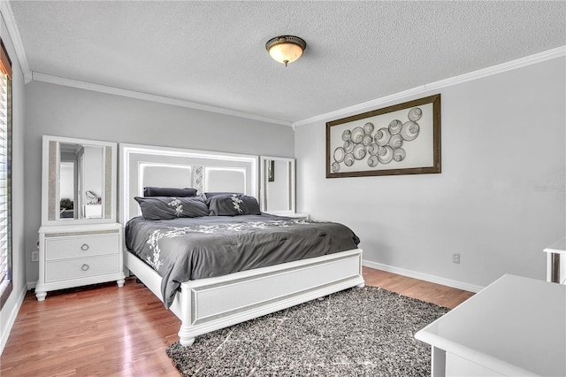 bedroom featuring crown molding, baseboards, wood finished floors, and a textured ceiling
