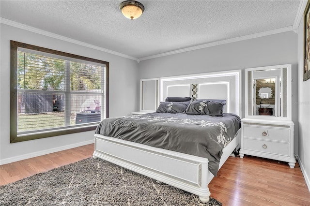 bedroom with crown molding, wood finished floors, baseboards, and a textured ceiling