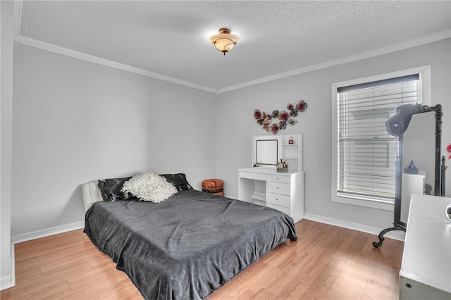 bedroom featuring crown molding, baseboards, light wood-type flooring, and a textured ceiling
