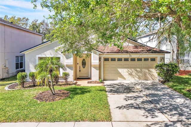 view of front of home featuring a front yard, an attached garage, stucco siding, and concrete driveway