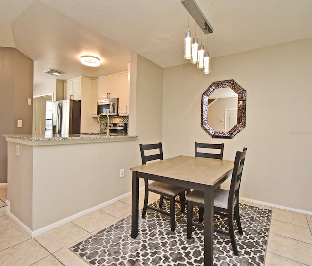dining room with baseboards, visible vents, and light tile patterned floors