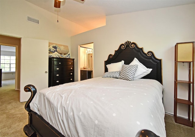 carpeted bedroom featuring ensuite bathroom, lofted ceiling, and visible vents