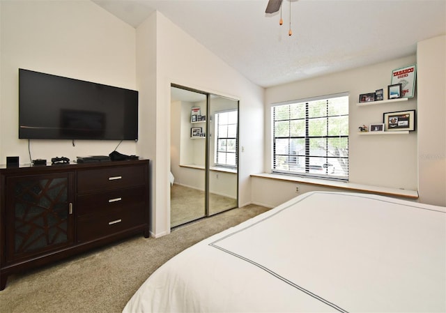 bedroom with a closet, carpet, baseboards, ceiling fan, and vaulted ceiling