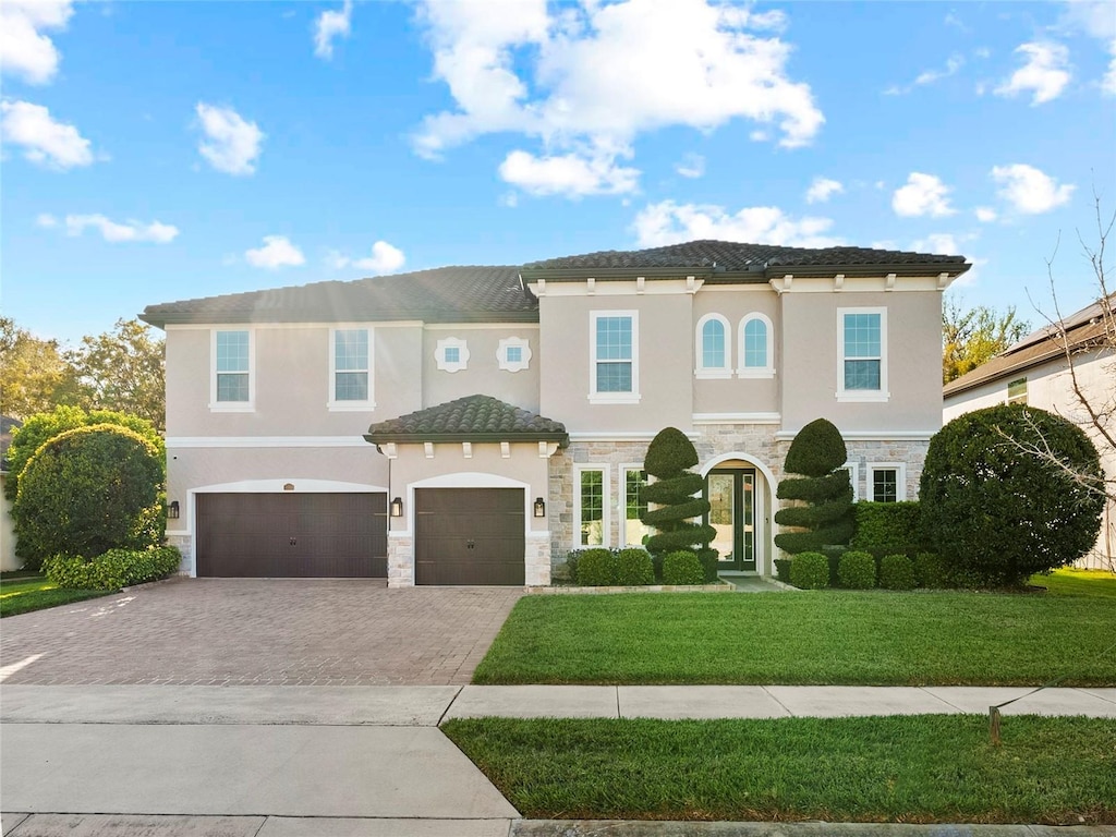 645 American Holly Pl, Oviedo, FL 32765 - mediterranean / spanish house with an attached garage, driveway, stone siding, and stucco siding