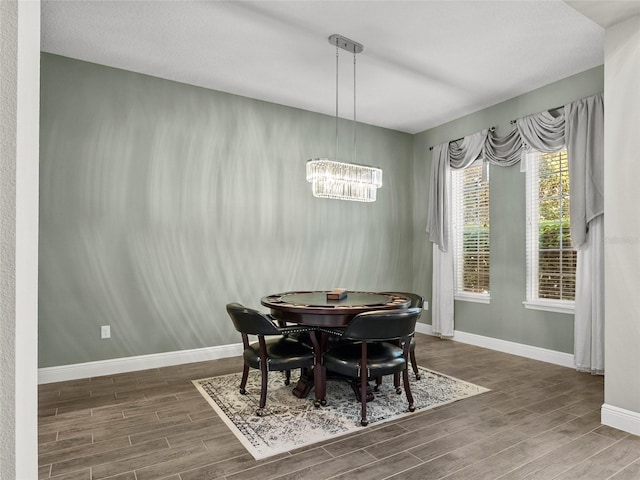 dining room with baseboards, a chandelier, and wood finished floors
