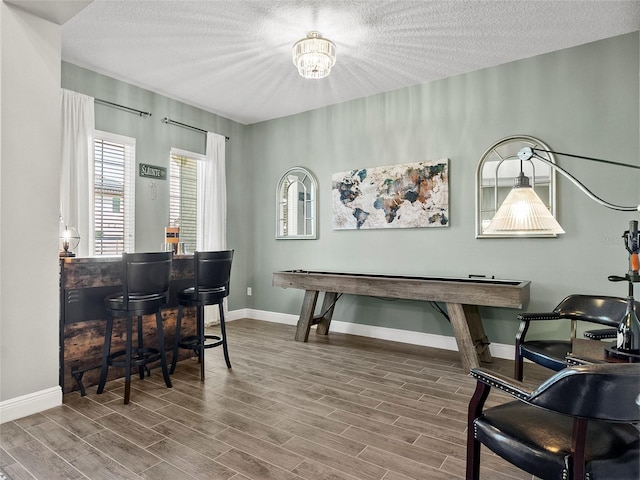 home office with baseboards, wood finished floors, and a textured ceiling