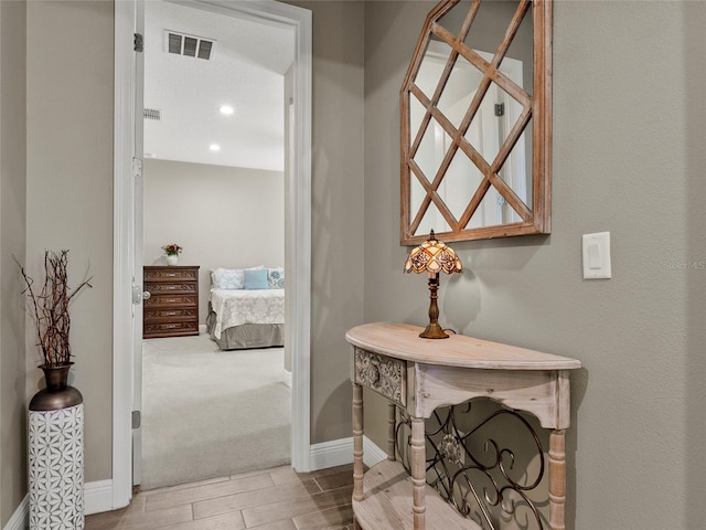 corridor with recessed lighting, wood finish floors, visible vents, and baseboards