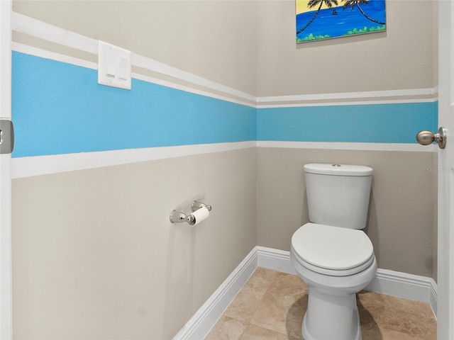bathroom with toilet and baseboards