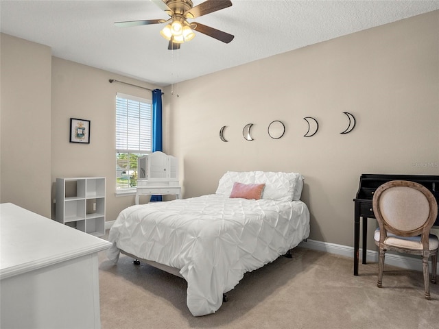 bedroom with a ceiling fan, baseboards, and light colored carpet