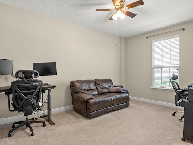 office with baseboards, a textured ceiling, a ceiling fan, and light colored carpet