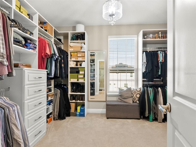 spacious closet featuring a notable chandelier and light colored carpet