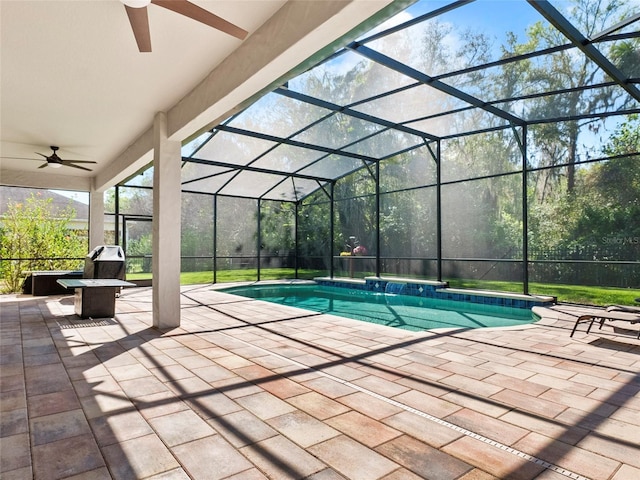 pool featuring ceiling fan, glass enclosure, area for grilling, and a patio