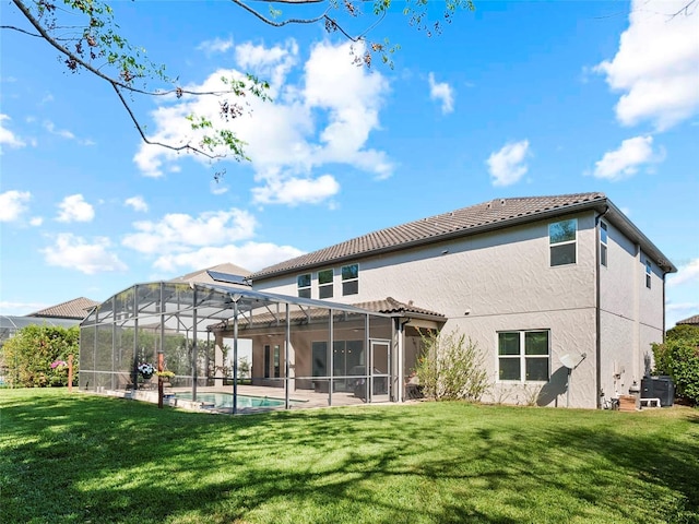 back of property with an outdoor pool, stucco siding, a tile roof, a lawn, and a lanai