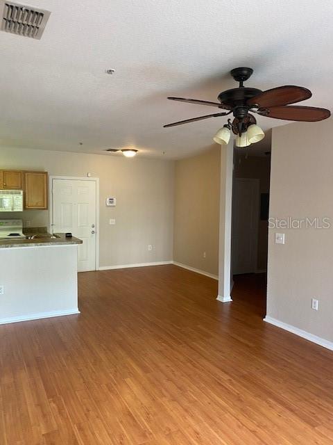 5550 E Michigan St Unit 2114, Orlando, FL 32822 - unfurnished living room featuring baseboards, ceiling fan, visible vents, and light wood-type flooring
