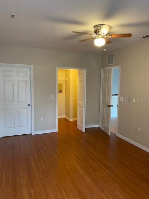 5550 E Michigan St Unit 2114, Orlando, FL 32822 - unfurnished bedroom with wood finished floors, baseboards, and visible vents