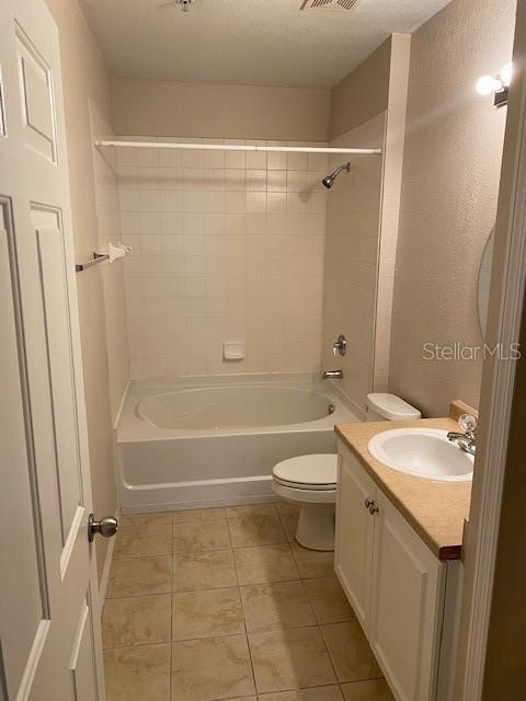 5550 E Michigan St Unit 2114, Orlando, FL 32822 - bathroom featuring vanity, shower / bath combination, toilet, tile patterned floors, and visible vents