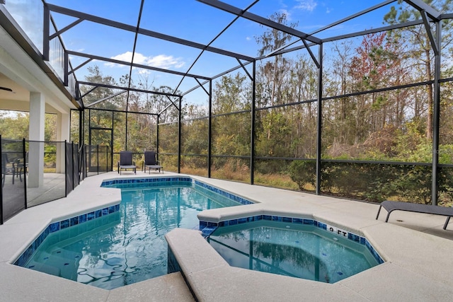 view of pool featuring a pool with connected hot tub, a lanai, and a patio