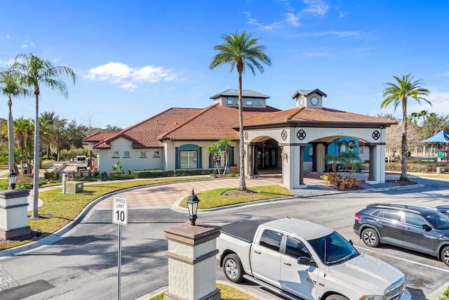 exterior space with stucco siding and a tile roof