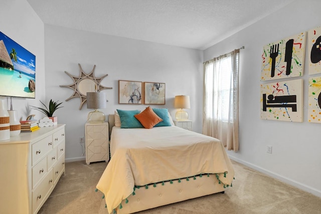 bedroom with light carpet, baseboards, and a textured ceiling
