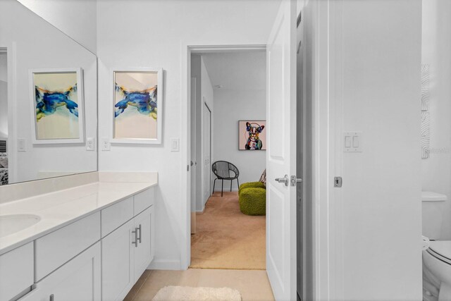 bathroom featuring toilet, vanity, tile patterned floors, and baseboards