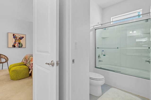 full bathroom featuring combined bath / shower with glass door and toilet