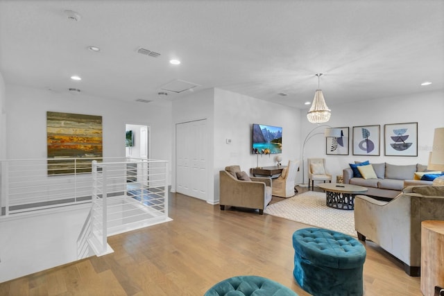 living area featuring visible vents, recessed lighting, light wood-type flooring, and attic access