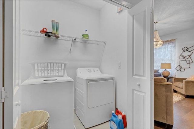 laundry area with wood finished floors, laundry area, and washer and clothes dryer