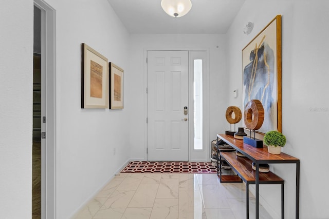 foyer entrance featuring marble finish floor and baseboards