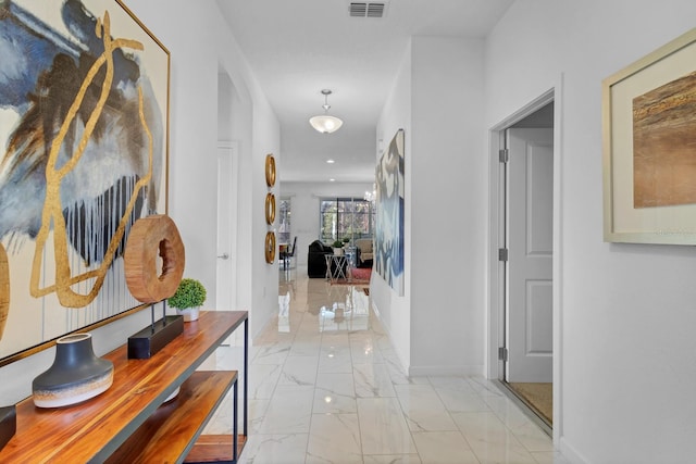 corridor featuring marble finish floor, baseboards, and visible vents