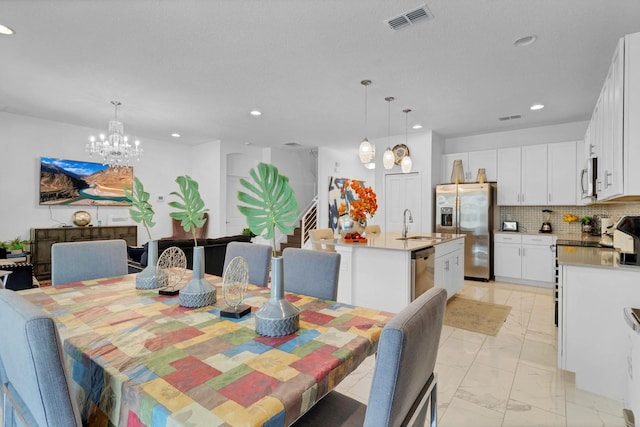 dining area featuring marble finish floor, visible vents, recessed lighting, and a notable chandelier