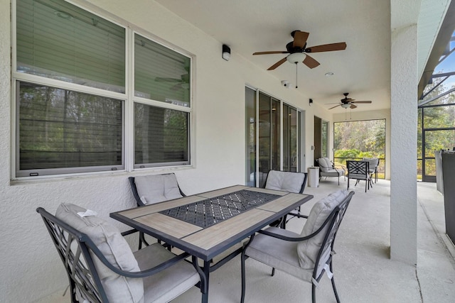 view of patio / terrace featuring a ceiling fan, glass enclosure, and outdoor lounge area